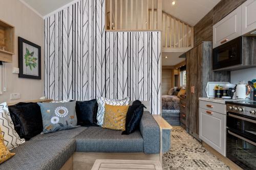 a living room with a couch and a kitchen at The Escape - Luxury Pod Close to Beach in Amroth