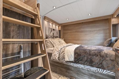 a bedroom with two beds and wooden walls at The Escape - Luxury Pod Close to Beach in Amroth