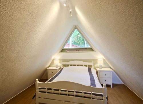 a bedroom with a bed in a attic with a window at Kingsdown Chalet No.5 in Kingsdown