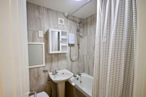 a bathroom with a sink and a shower curtain at Kingsdown Chalet No.5 in Kingsdown