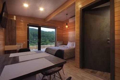 a room with a bed and a bedroom with a window at La Kuburi in Slănic-Moldova