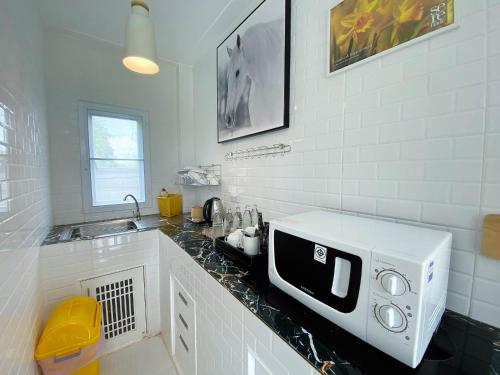 a kitchen with a microwave on a counter at ภูฝ้ายวิลล่า Phufai villa in Chiang Khan