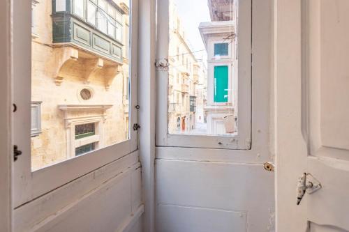 an open door with a view of the city at Superbly Located Cosy 2-Bedroom Apartment Valletta in Valletta