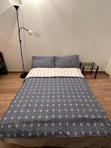 - un lit dans une chambre avec une couette bleue dans l'établissement Un studio au sacré cœur Montmartre, à Paris