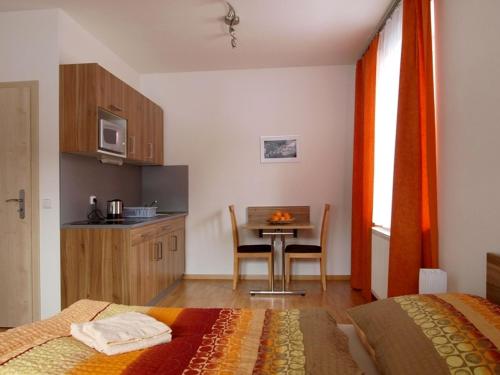 - une chambre avec une cuisine, une table et un lit dans l'établissement Penzion a restaurace Sklář, à Karolinka