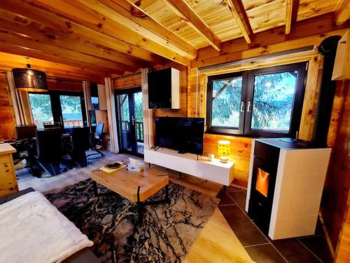 a living room with a couch and a table at Gîte le Chalet Aura & jacuzzi in Abreschviller