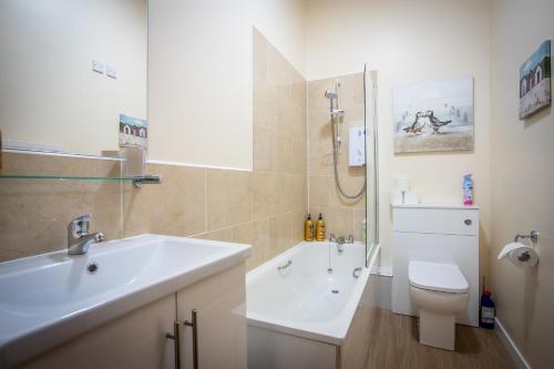 a bathroom with a sink and a toilet and a shower at Douglas House Apartments in Nairn