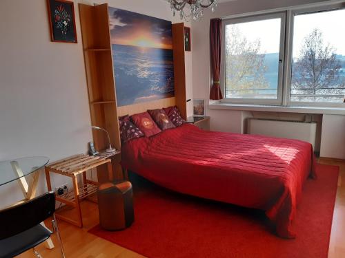 a bedroom with a red bed and a window at Arpadtravel in Budapest