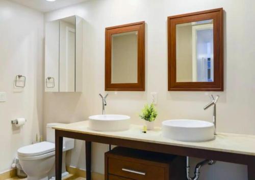 een badkamer met 2 wastafels, een toilet en spiegels bij Luxurious 1BR Condo At Icon Brickell in Miami