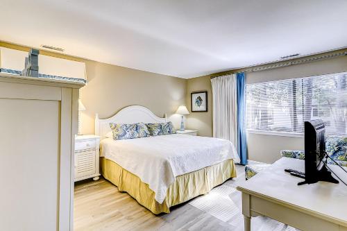 1 dormitorio con 1 cama y escritorio con ordenador en Harbour Master 103 en Hilton Head Island