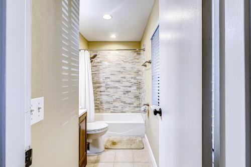 a bathroom with a white toilet and a brick wall at Harbour Master 103 in Hilton Head Island
