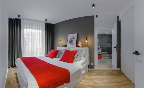 1 dormitorio con 1 cama grande con almohadas rojas en Apartamenty Homely Place - Parking, en Poznan