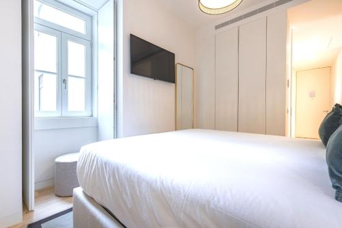 a bedroom with a bed and a flat screen tv at Ando Living - Douradores House in Lisbon