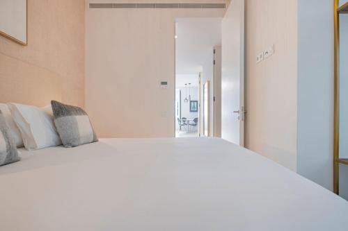 a bedroom with a large white bed and an open door at Ando Living - Douradores House in Lisbon