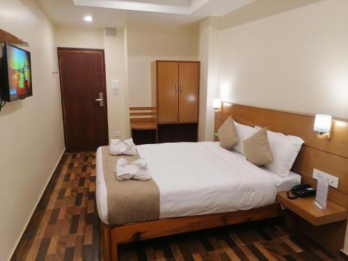 a hotel room with a bed and a television at Urban Boutique Hotel Pokhara in Pokhara