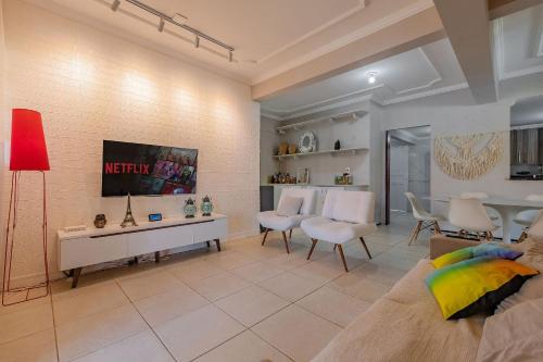 a living room with a tv on a wall at Casa Dunas - Espaço e Conforto em PDD by Carpediem in Aquiraz