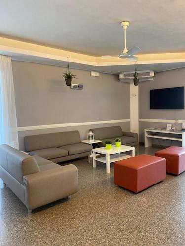 a living room with couches and a flat screen tv at Hotel Mizar in Rimini