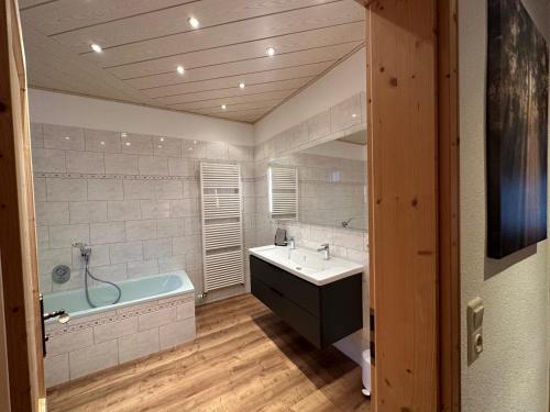 ein Badezimmer mit einer Badewanne, einem Waschbecken und einer Badewanne in der Unterkunft Ferienhaus "Kleines Domizil" Altenberg - direkt im Zentrum von Altenberg gegenüber vom Skilift in Kurort Altenberg