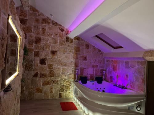 La salle de bains est pourvue d'une baignoire avec un éclairage violet. dans l'établissement Studio luxe jacuzzi croisette, à Cannes