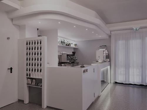 a white room with a kitchen with a counter at Hotel Mizar in Rimini