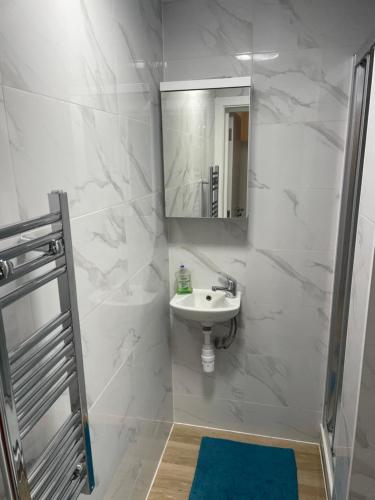 Baño blanco con lavabo y espejo en London Studios in BR54LT, en Saint Mary Cray