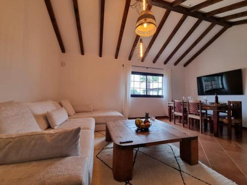a living room with a couch and a table at Surf&fun heated pool villa in La Oliva