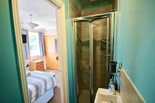 a bathroom with a shower with a bed and a sink at Gerald's Place in Deal