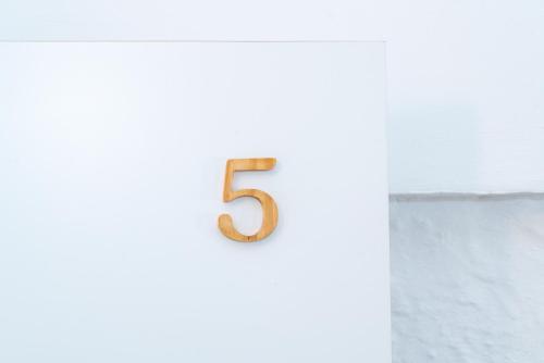 a number five on a wall with a white wall at Encant de Alaior Boutique Hotel in Alaior