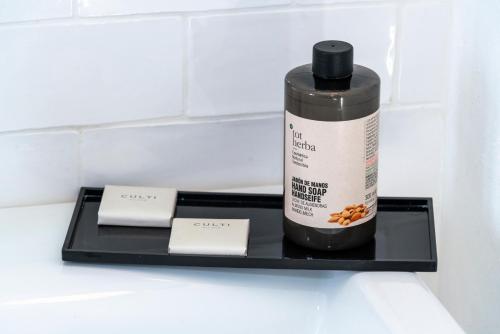 a black bottle of seasoning sitting on a black shelf at Encant de Alaior Boutique Hotel in Alaior