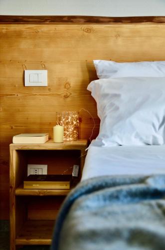 a bedroom with a bed and a night stand with a candle at Case Verdi in Bardonecchia