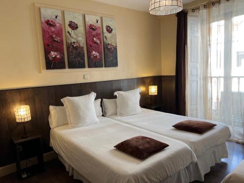 1 dormitorio con 1 cama blanca grande y 2 almohadas en THC Bergantin Hostel en Madrid