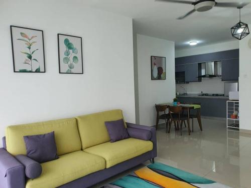 a living room with a yellow couch and a kitchen at SYG 4 Dwiputra Homestay Putrajaya 3 Bilik Tidur in Putrajaya