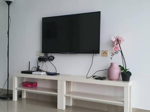a tv sitting on a white table in a living room at SYG 4 Dwiputra Homestay Putrajaya 3 Bilik Tidur in Putrajaya