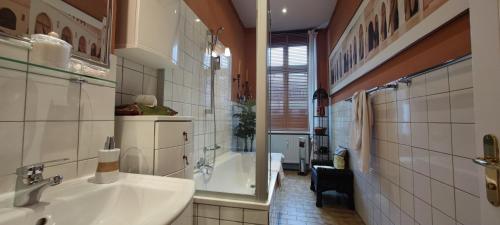 a bathroom with a sink and a bath tub at Boutique Hotel Mittendrin Berlin in Berlin