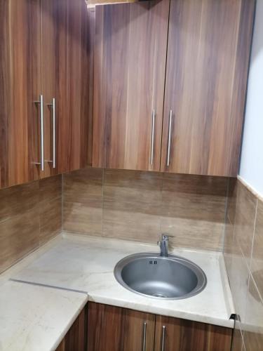 a bathroom with a sink and wooden cabinets at Vila Vlajić 2015 in Gornje Pale