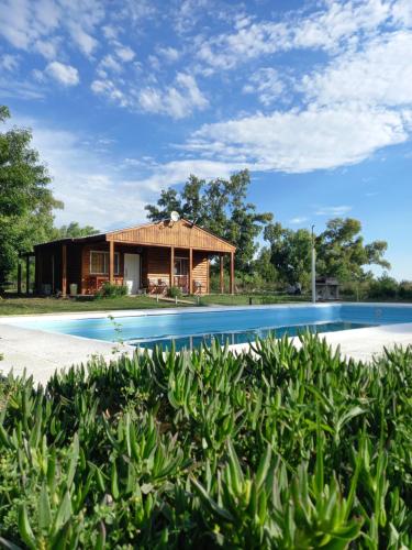 a house with a pool in front of it at Cabaña El Encuentro in San Carlos de Bolívar