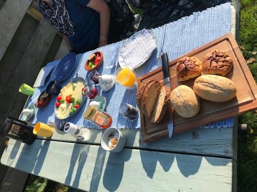 einen Picknicktisch mit einem Tablett mit Essen und Brot in der Unterkunft Huisje onder de Linden in Munnekeburen