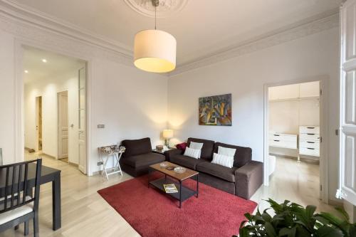 a living room with a couch and a red rug at ApartEasy - Passeig de Gracia in Barcelona