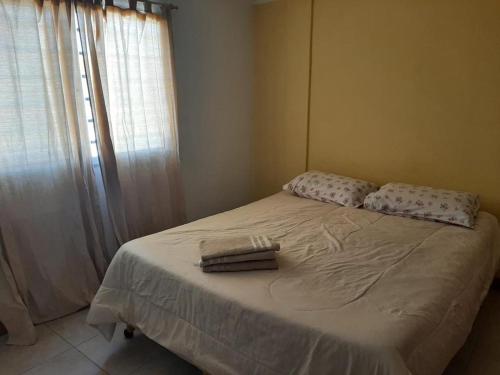 een slaapkamer met een bed met twee handdoeken erop bij Gadano Suites in General Roca