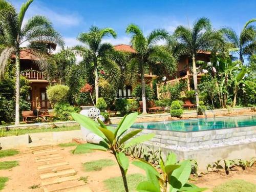 a resort with a swimming pool and palm trees at Eagles Nest Cabanas in Tangalle