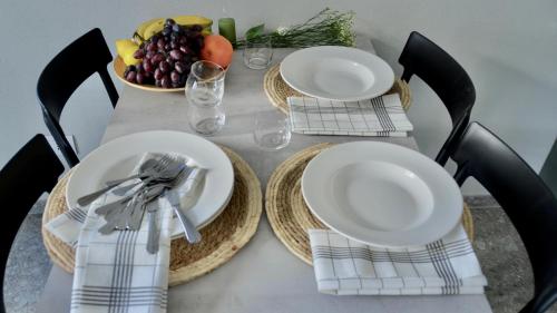 a table with two plates and a bowl of fruit at Case Verdi in Bardonecchia