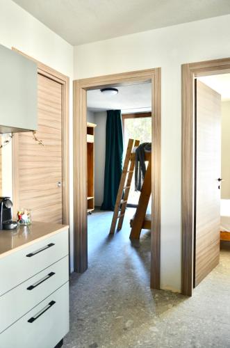 a kitchen with a door leading to a ladder at Case Verdi in Bardonecchia