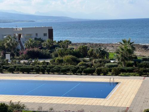 a swimming pool with a view of the ocean at True front line apartment in Tatlisu North Cyprus in Küçükerenköy