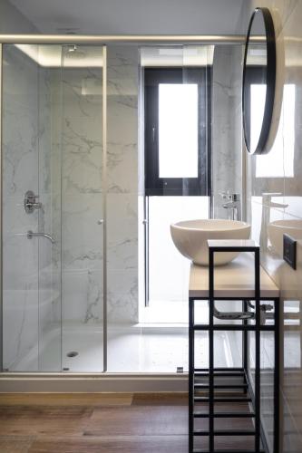 a bathroom with a shower and a sink and a mirror at Arena Suites in Mar del Plata