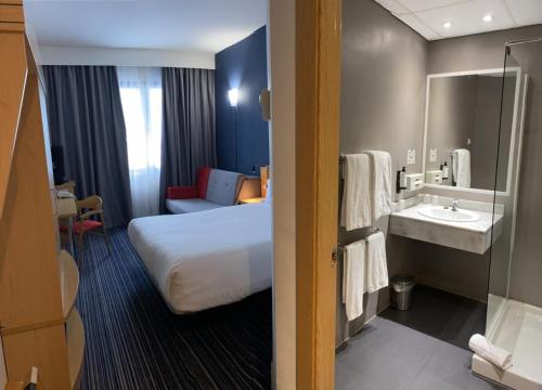 a hotel room with a bed and a sink at Holiday Inn Express San Sebastian de los Reyes, an IHG Hotel in San Sebastián de los Reyes