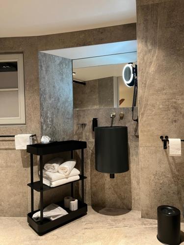 ein Badezimmer mit einem Spiegel und einem Regal mit Handtüchern in der Unterkunft O verso du Château - STUDIO 22 in Barr