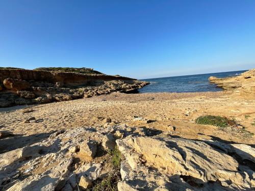 a rocky beach with the ocean in the background at True front line apartment in Tatlisu North Cyprus in Küçükerenköy