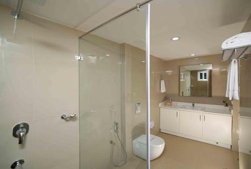 a bathroom with a shower and a toilet and a sink at The Fog Munnar (Resort & Spa) in Munnar