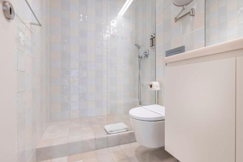 a bathroom with a toilet and a glass shower at Ando Living - Douradores House in Lisbon