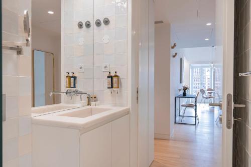 a white bathroom with a sink and a mirror at Ando Living - Douradores House in Lisbon